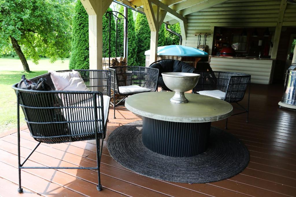 a patio with a table and chairs on a porch at Avar puhkekompleks saunaga in Kuusiku