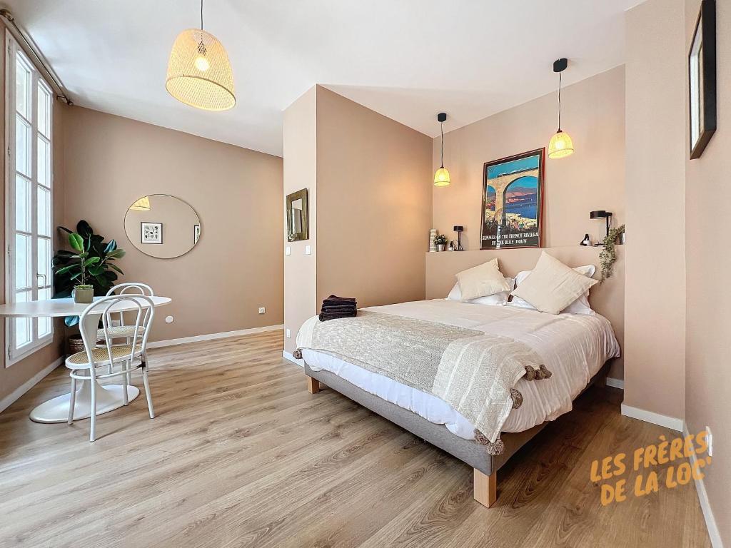 een slaapkamer met een bed en een tafel erin bij Magnifique Studio - Hyper Central & Climatisation - Les Frères de la Loc' in Marseille