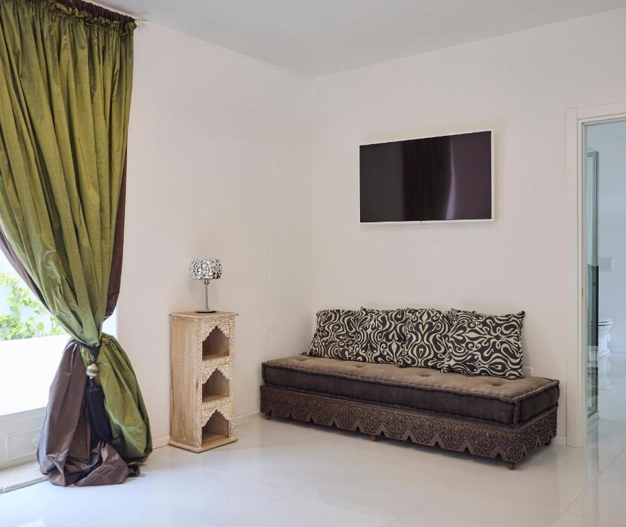 a living room with a couch and a television at La Casa E Il Mare, Private Bay Hotel in Mattinata