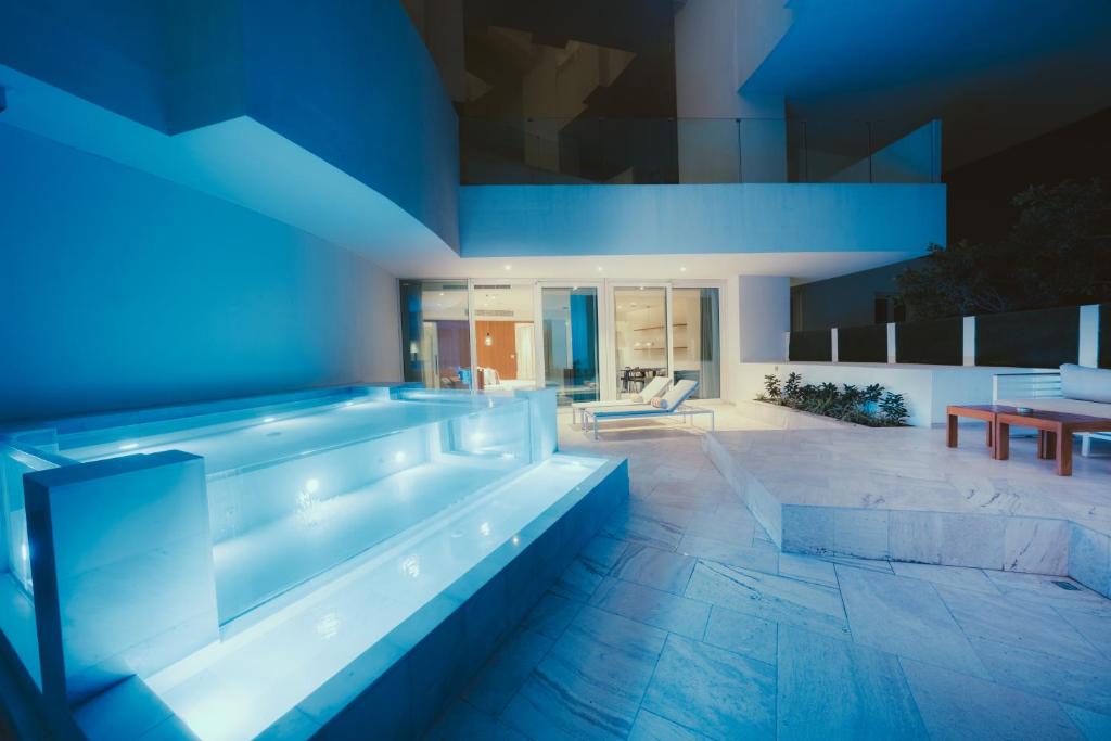a swimming pool in a house with blue lighting at FIVE Jumeirah Village in Dubai