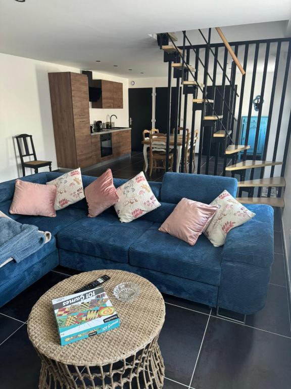 un salon avec un canapé bleu et une table dans l'établissement Le cottage champêtre, à Escaudoeuvres