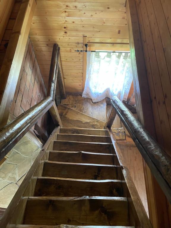 a staircase in a wooden cabin with a window at Brvnare Sekulic in Sekulić 