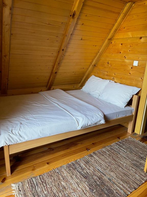 a bed in a room with a wooden ceiling at Brvnare Sekulic in Sekulić 