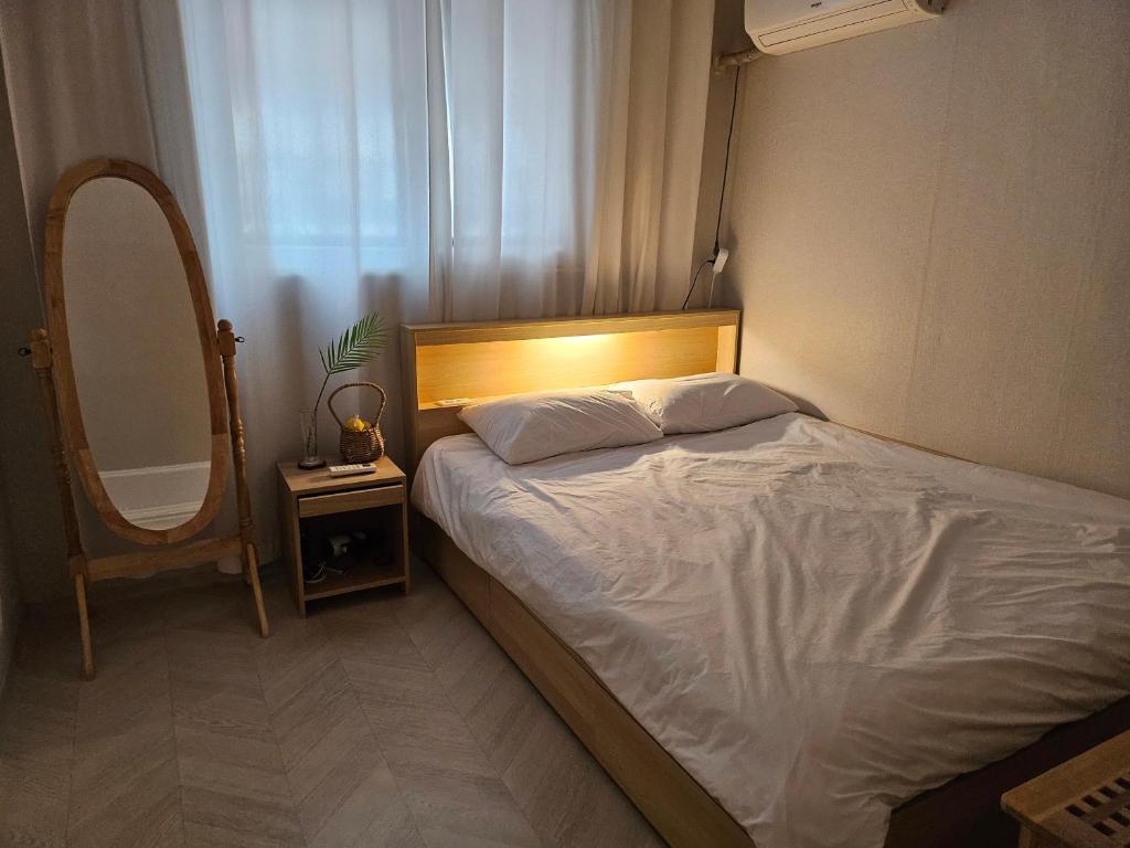 a bedroom with a bed and a mirror and a chair at Honey Sleep Room - 2BR Cosy House at Jamsil, FreeParking in Seoul
