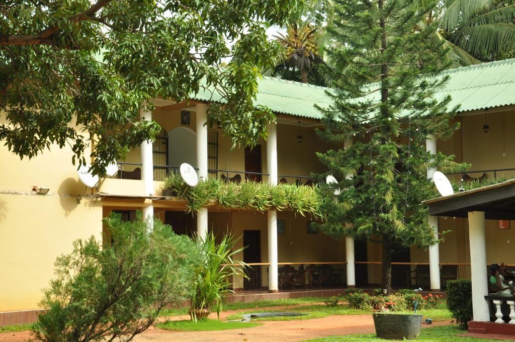 a building with trees in front of it at Sujatha Tourist Rest in Dambulla