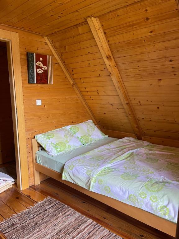 a bedroom with a bed in a wooden cabin at Brvnare Sekulic in Sekulić 