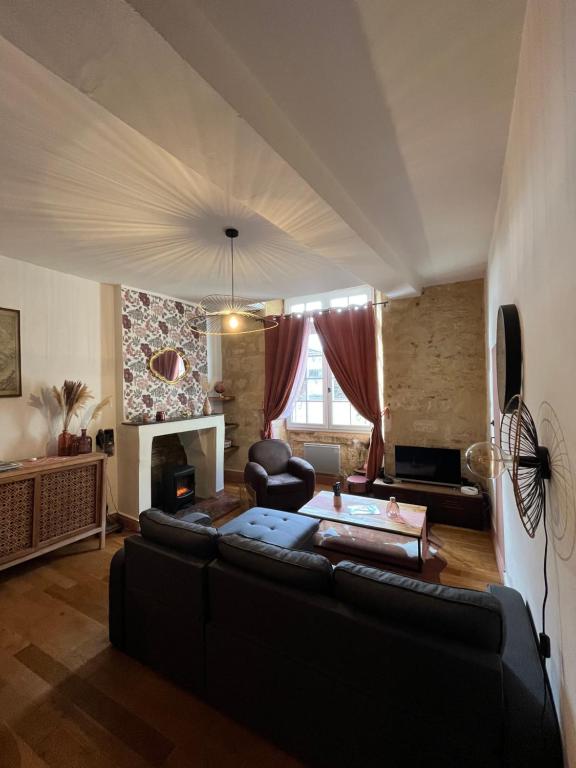 Una sala de estar con un sofá y un televisor. en Le Pink Lady Appartement centre historique de Bergerac, en Bergerac