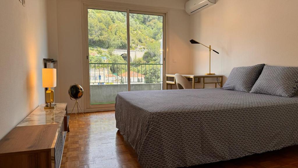 une chambre avec un lit et une grande fenêtre dans l'établissement Élégant 3 pièces, 2 chambres, 4 pers, clim, Wi-fi, proche des plages, à Nice