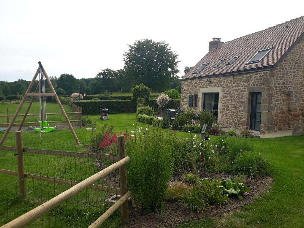 a garden in front of a stone house at Gite de la Houssière in Joué-du-Bois