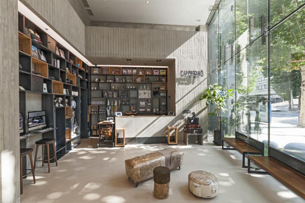 a room with a library with a table and benches at Hotel Cappuccino in Seoul