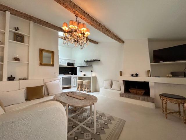ein Wohnzimmer mit einem Kronleuchter, einem Sofa und einem Tisch in der Unterkunft Maison Saint Tropez in Saint-Tropez