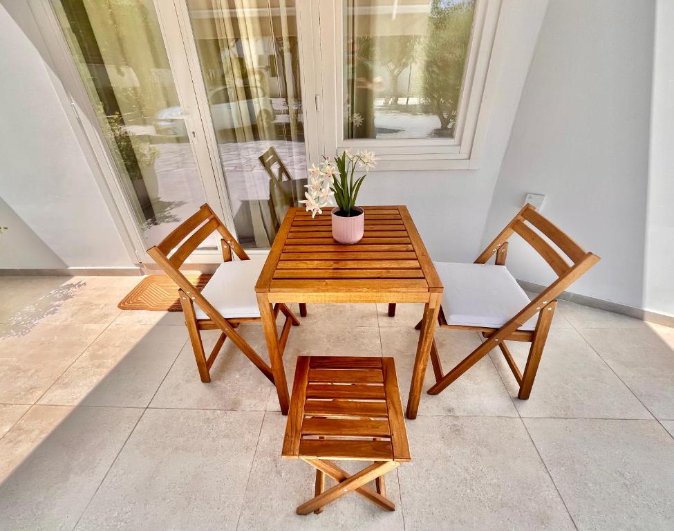 a wooden table with two chairs and a potted plant at The Courtyard Episkopi Guest Houses in Episkopi Limassol