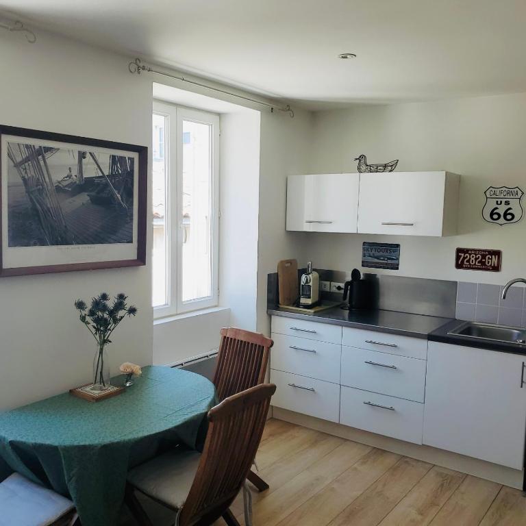 une cuisine avec une table et un comptoir dans l'établissement LES MARIETTES, à La Rochelle