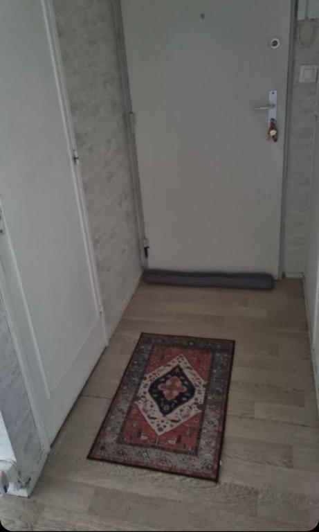 une chambre avec un tapis à l'étage, à côté d'une porte dans l'établissement Family Home, à Fleury-Mérogis