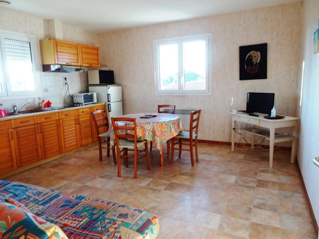 une cuisine et une salle à manger avec une table et des chaises dans l'établissement APPARTEMENT MER du samedi au samedi, à Saint-Georges-de-Didonne