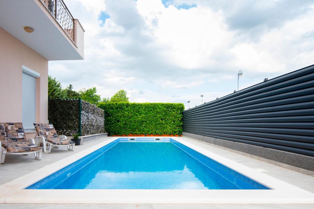 a swimming pool in the backyard of a house at Two bedroom apartment Karmen with pool in Sinj