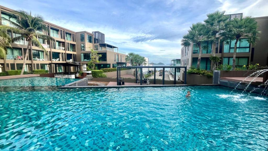 una piscina con fuente en un edificio en Pixels - Ocean Front Studio with Pool View Cape Panwa, en Ban Ao Makham