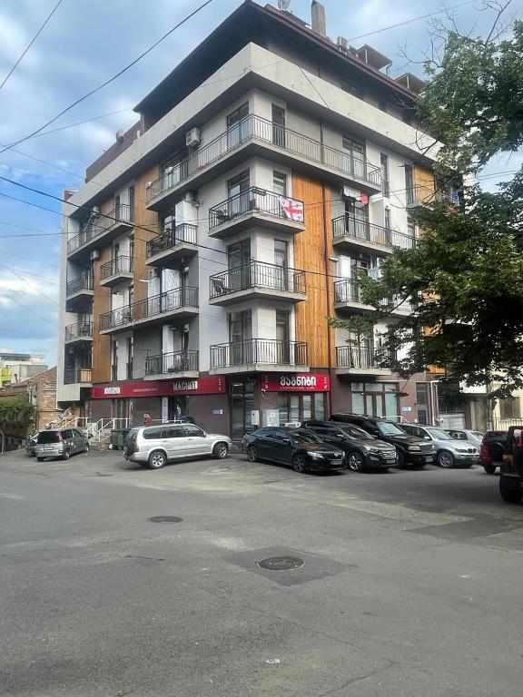 a large building with cars parked in front of it at Comfy Nook Apartment in Tbilisi City