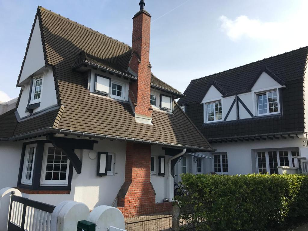une maison avec une cheminée en briques et un toit dans l'établissement Le Touquet - Villa de vacances proche plage, à Le Touquet-Paris-Plage