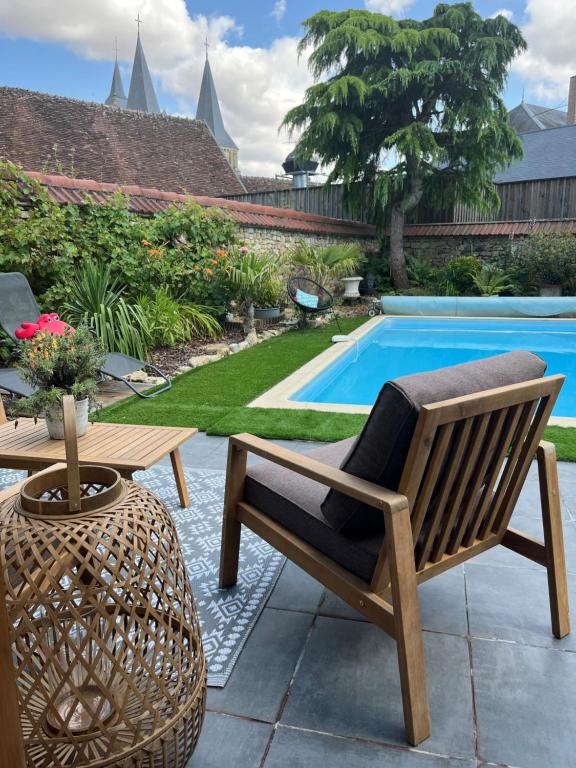 a patio with a chair and a table and a pool at Relais Saint-Jean Levroux in Levroux