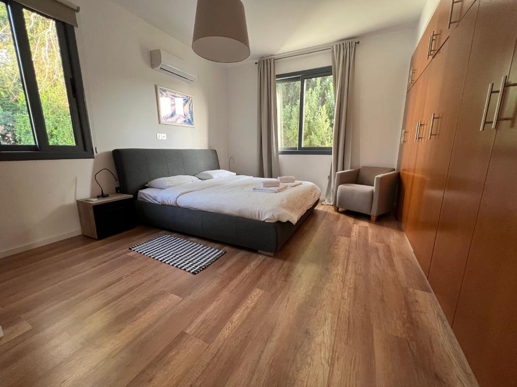 a bedroom with a bed and a chair in it at Julipapas Gardens in Paphos