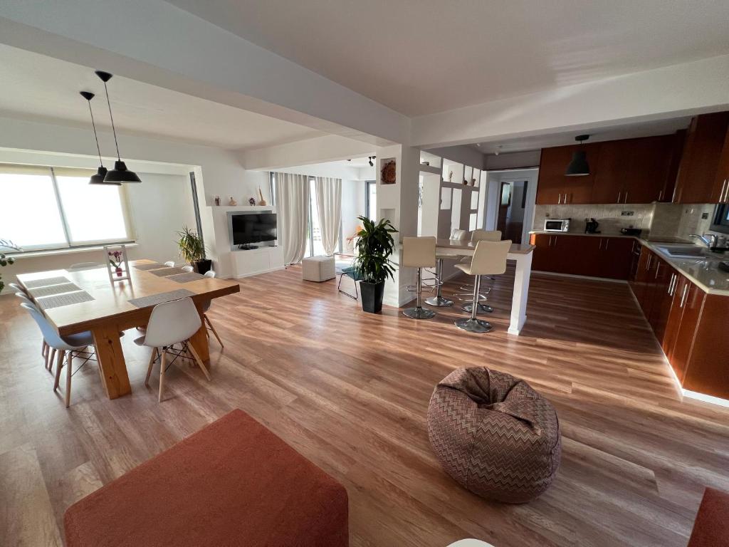 a large living room with a table and a kitchen at Julipapas Gardens in Paphos