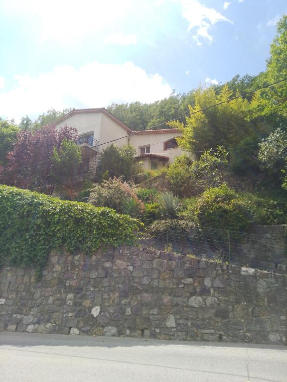 une maison au-dessus d'un mur en pierre dans l'établissement Les Lauriers, à Roquebillière