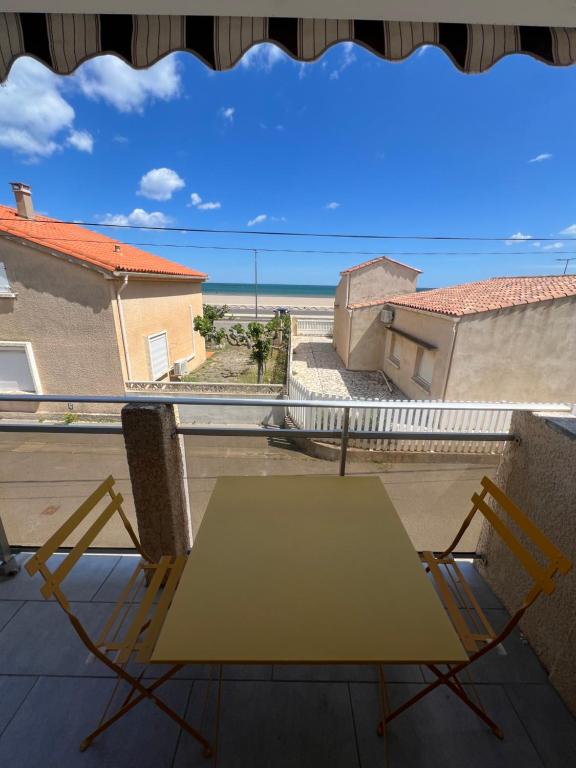 une table et des chaises sur un balcon avec vue sur l'océan dans l'établissement Le Rascassou appartement vue sur la mer, à Narbonne