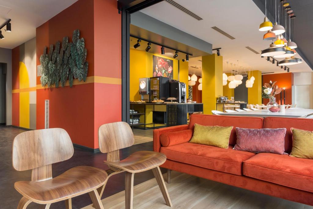 a living room with a couch and some chairs at B&B Hotel Milano Central Station in Milan