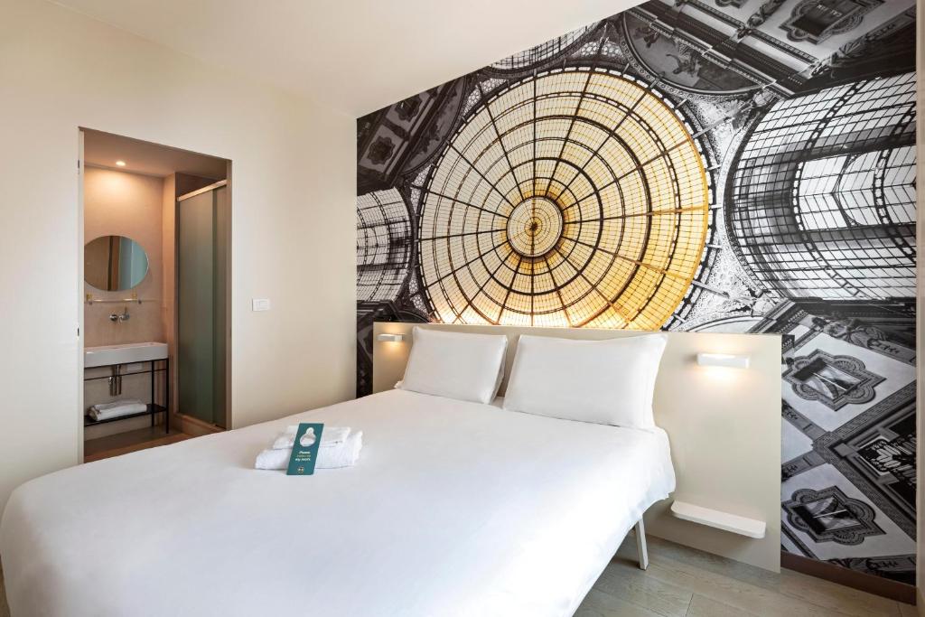 a bedroom with a white bed and a wall mural at B&B Hotel Milano Central Station in Milan