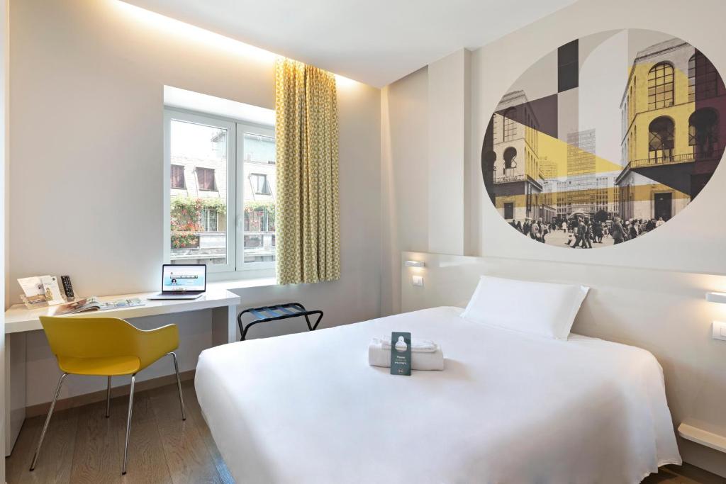 a hotel room with a white bed and a desk at B&B Hotel Milano Central Station in Milan