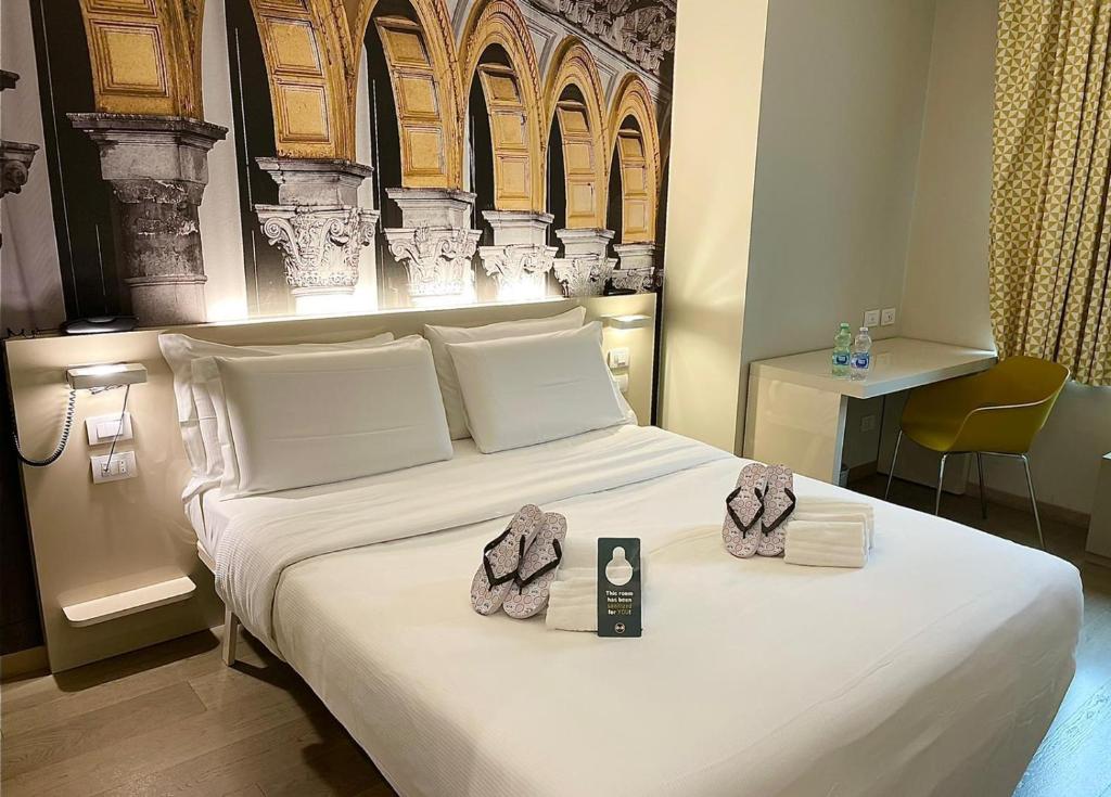 a hotel room with a white bed with two towels at B&B Hotel Milano Central Station in Milan