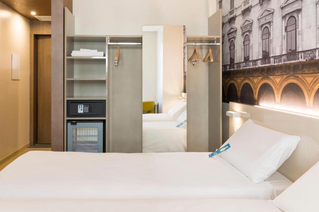 a hotel room with two beds and a closet at B&B Hotel Milano Central Station in Milan