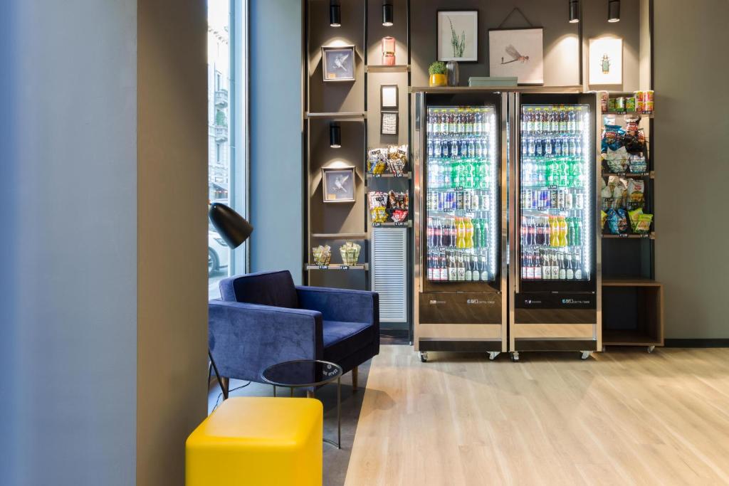a room with a blue chair and a vending machine at B&B Hotel Milano Central Station in Milan