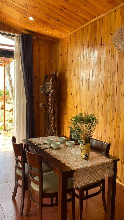 un tavolo da pranzo con sedie e una parete in legno di Home of bong & gao a B'su M'rac