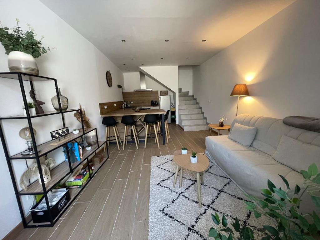 un salon avec un canapé et une table dans l'établissement Maison de village rénovée et équipée, à Saint-Nazaire-le-Désert