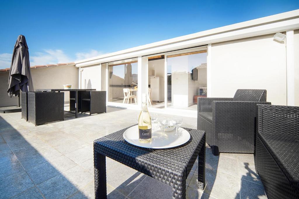 - une bouteille de vin assise sur une table sur une terrasse dans l'établissement La tropézienne, à Cassis