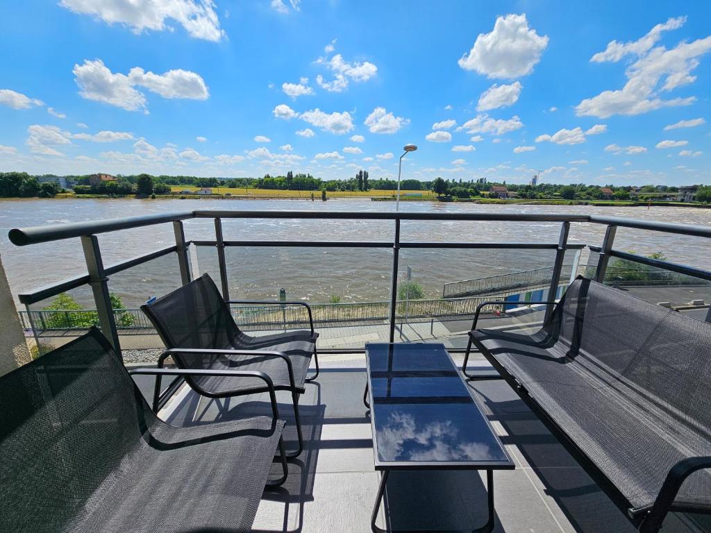 d'un balcon avec des chaises et une vue sur la rivière. dans l'établissement Appartement en bord de seine, à Ablon-sur-Seine