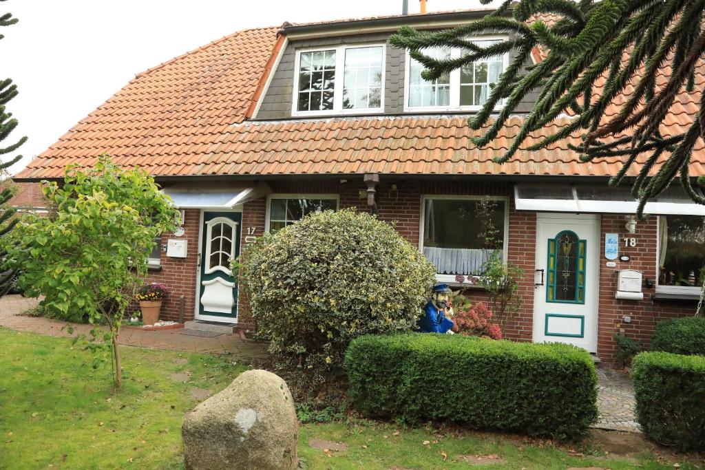 a house with two people sitting in front of it at Sahneschnittchen in Hage