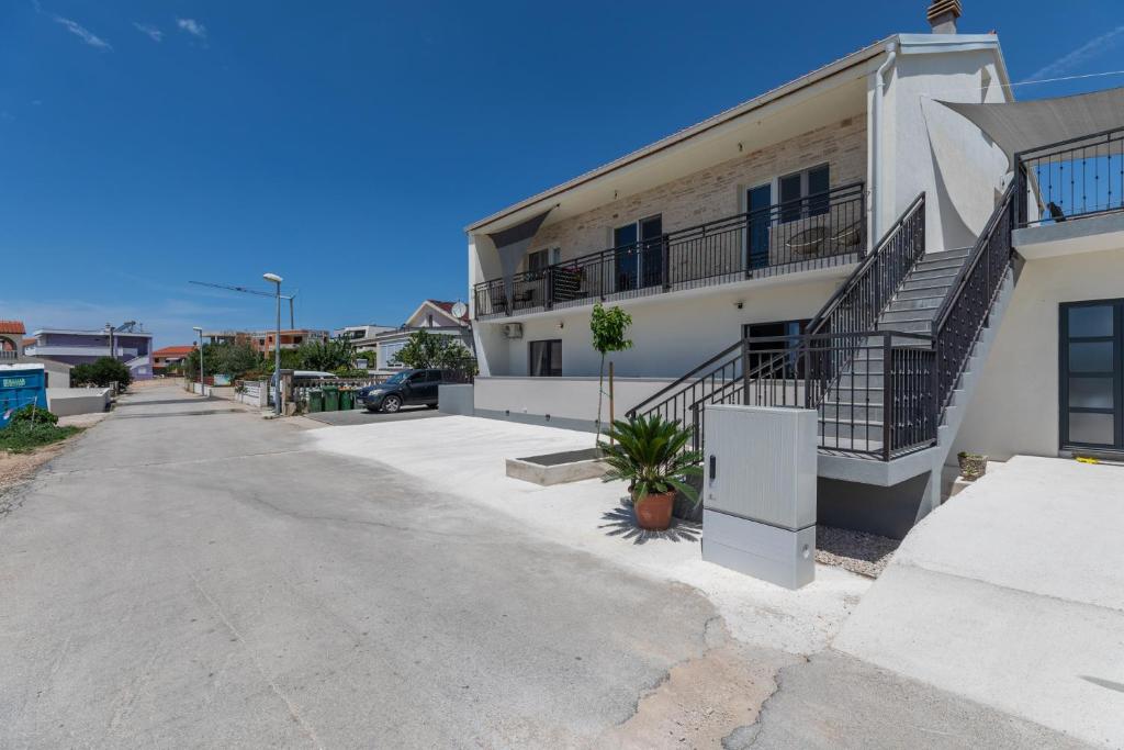 un edificio con escaleras al lado de una calle en New apartment Denis 2, en Vodice
