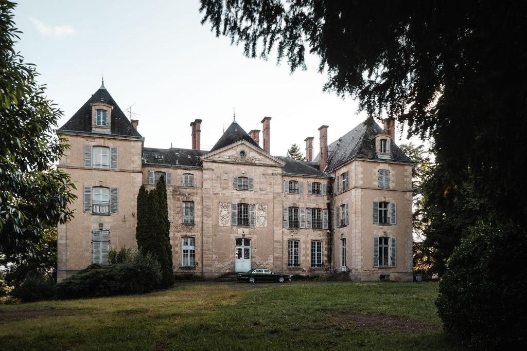 an old mansion with a car parked in front of it at Château de Sainte-Sévère in Sainte-Sévère-sur-Indre