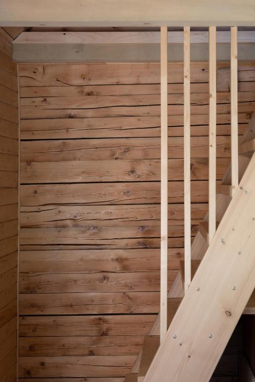 a wooden staircase in a room with a wooden wall at Kalna Smīžu pirtiņa in Melturi