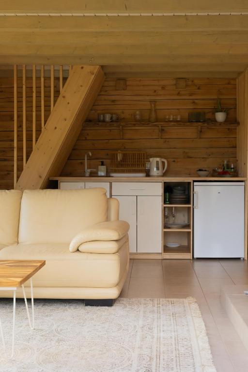 a living room with a couch and a kitchen at Kalna Smīžu pirtiņa in Melturi