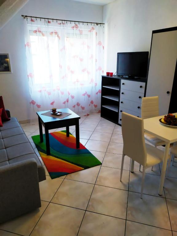 a living room with a table and a colorful rug at Apartamenty Plac Neptuna in Międzyzdroje