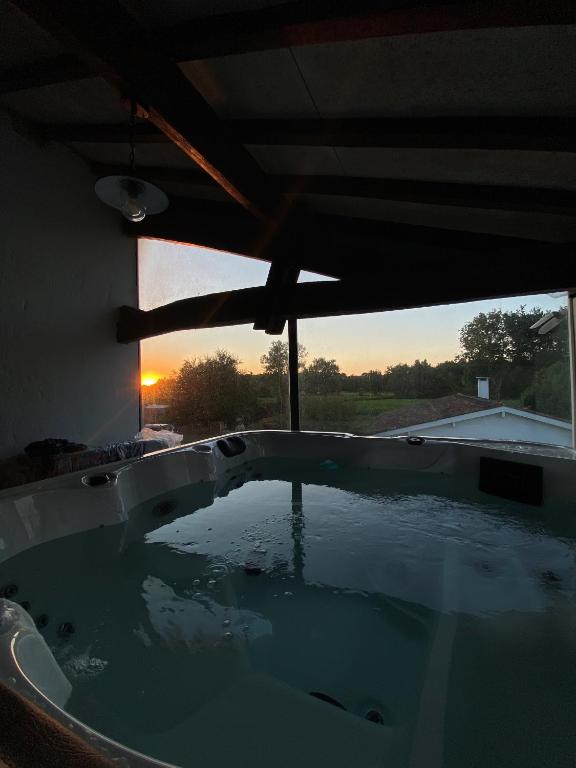 d'un bain à remous avec vue sur le coucher du soleil en arrière-plan. dans l'établissement Maison de charme au cœur du vignoble médocain avec un Spa, à Listrac-Médoc
