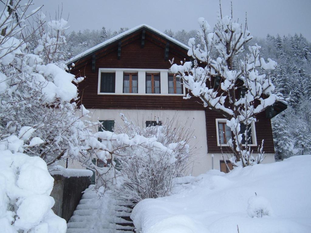 une maison recouverte de neige devant une maison dans l'établissement La PASTOURELLE, à Villard-de-Lans