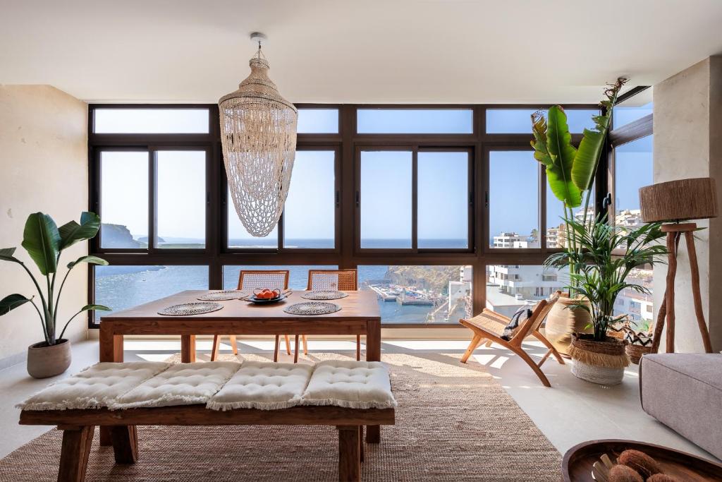 een woonkamer met een tafel en een groot raam bij Bahía Apartments in Icod de los Vinos
