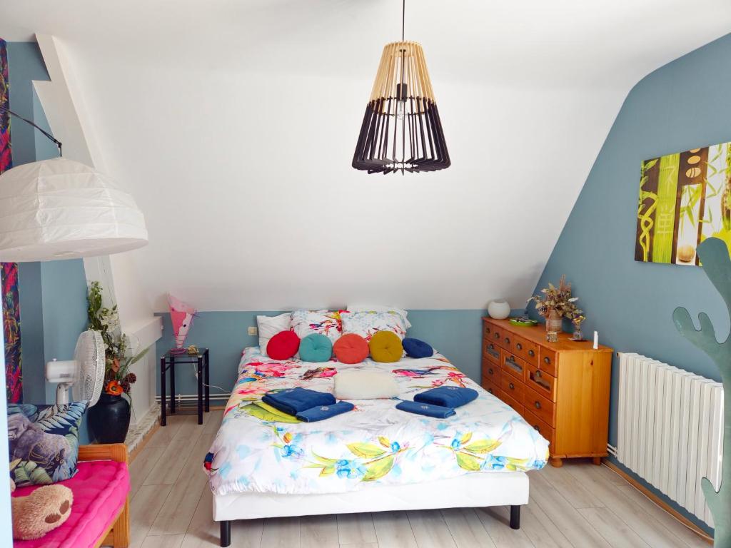 - une chambre avec un lit et des oreillers colorés dans l'établissement Écrin de Seigy, 5 minutes du ZOO de BEAUVAL, à Seigy