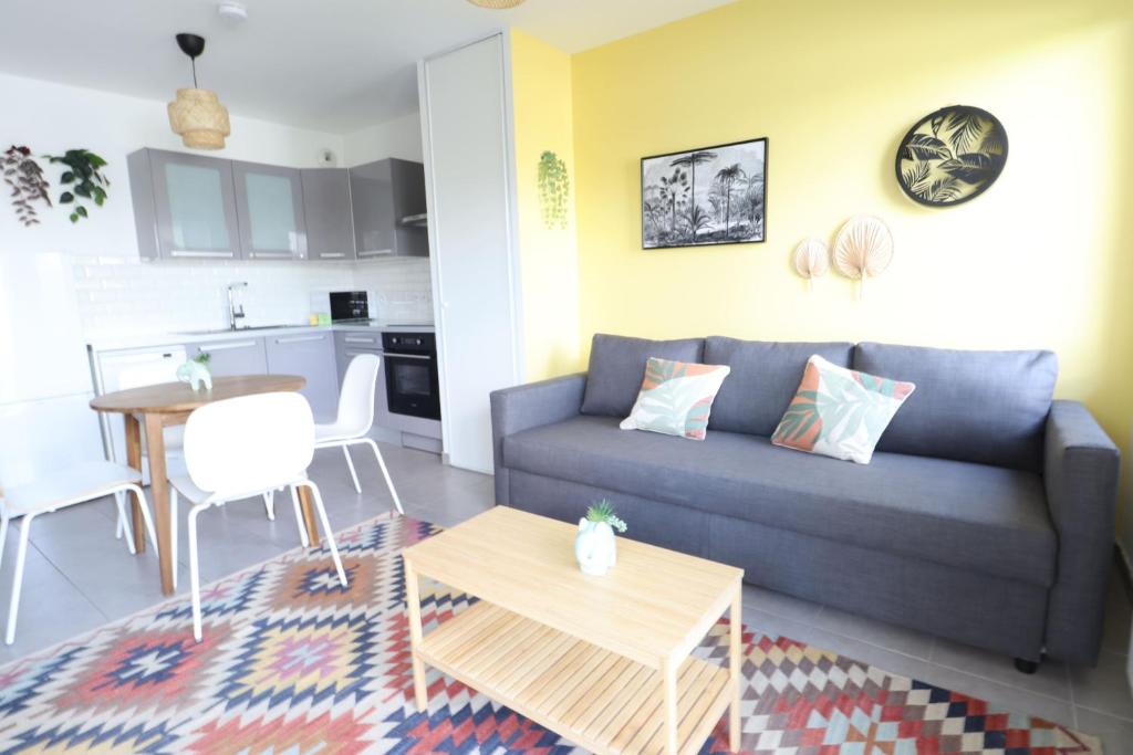 un salon avec un canapé et une table dans l'établissement Jungle Trip By Plaza - Proche Disneyland Paris, à Montévrain