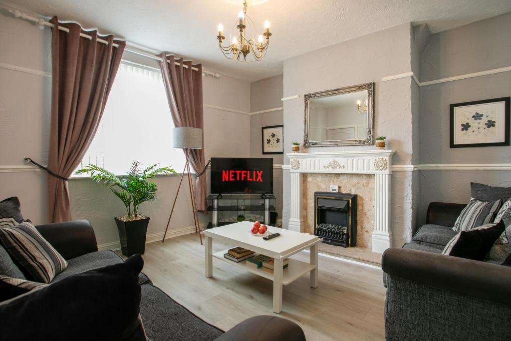 Una sala de estar con chimenea y televisión. en Manvers House, Rotherham for contractors, Families, free parking, Spacious, WIFI etc, en Wath upon Dearne